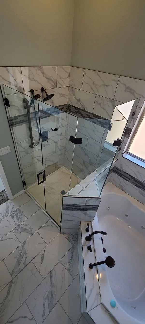 Neo-angle glass shower enclosure on a knee wall with matte black hardware